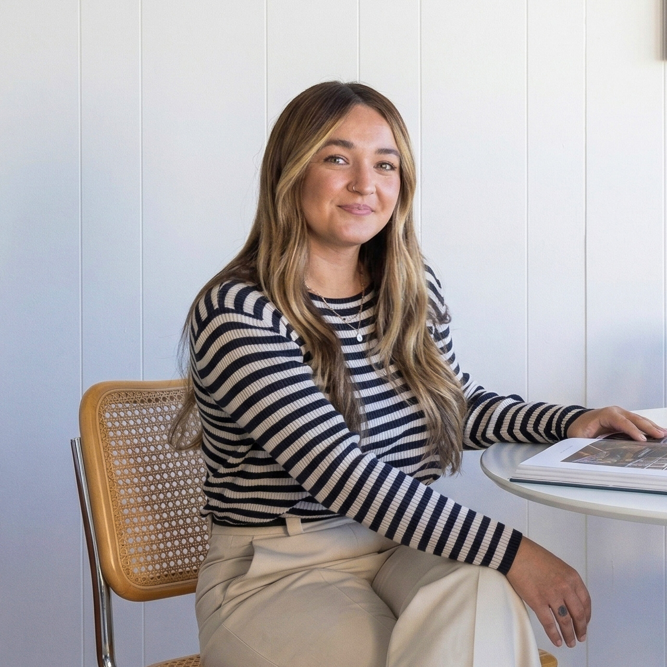 Portrait of Chloe Darché Maggs sitting at a desk in South Harlow Interiors.