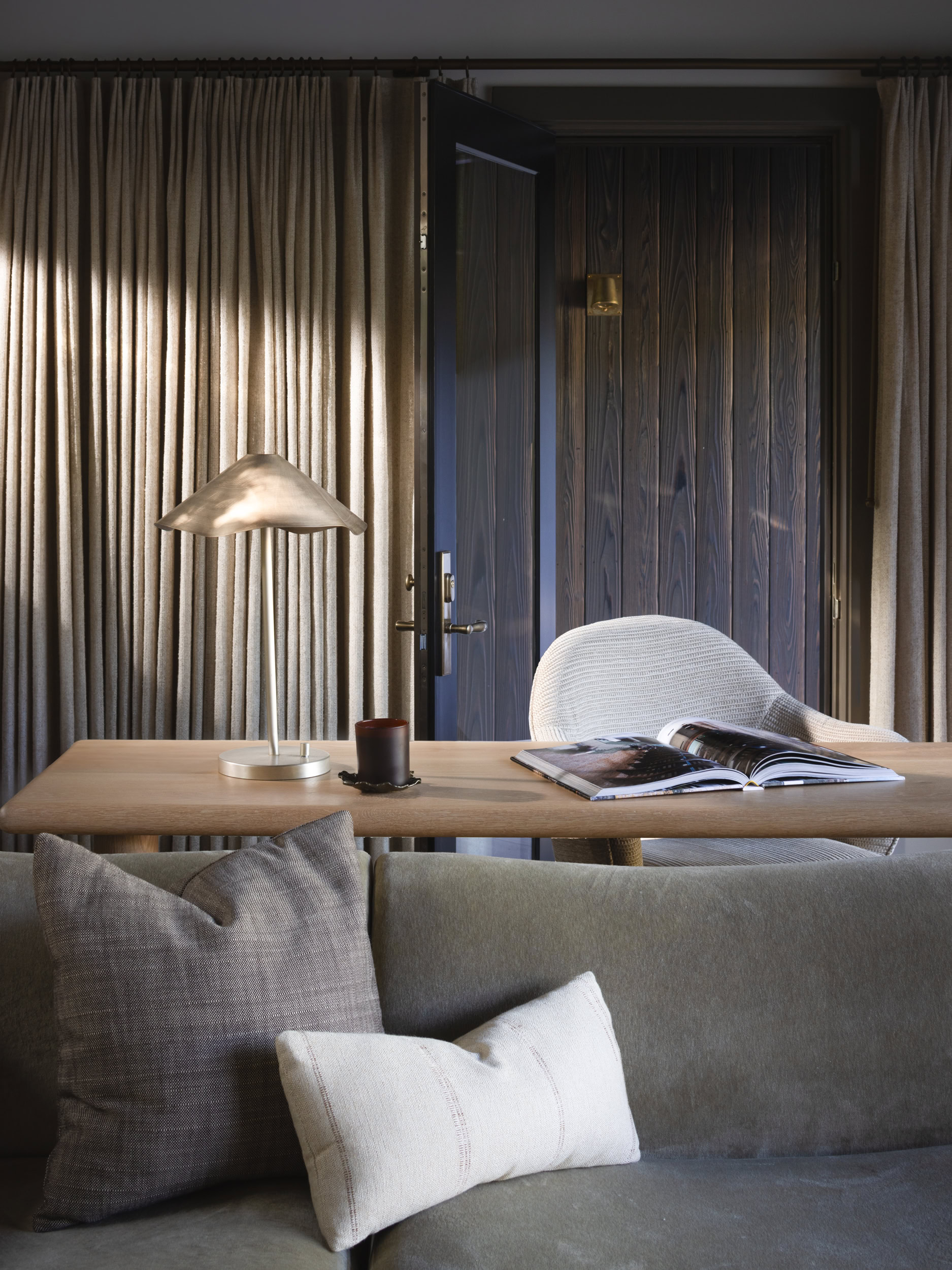 Elegant home office featuring wooden wall panels, soft lighting, and comfortable seating for a styli.