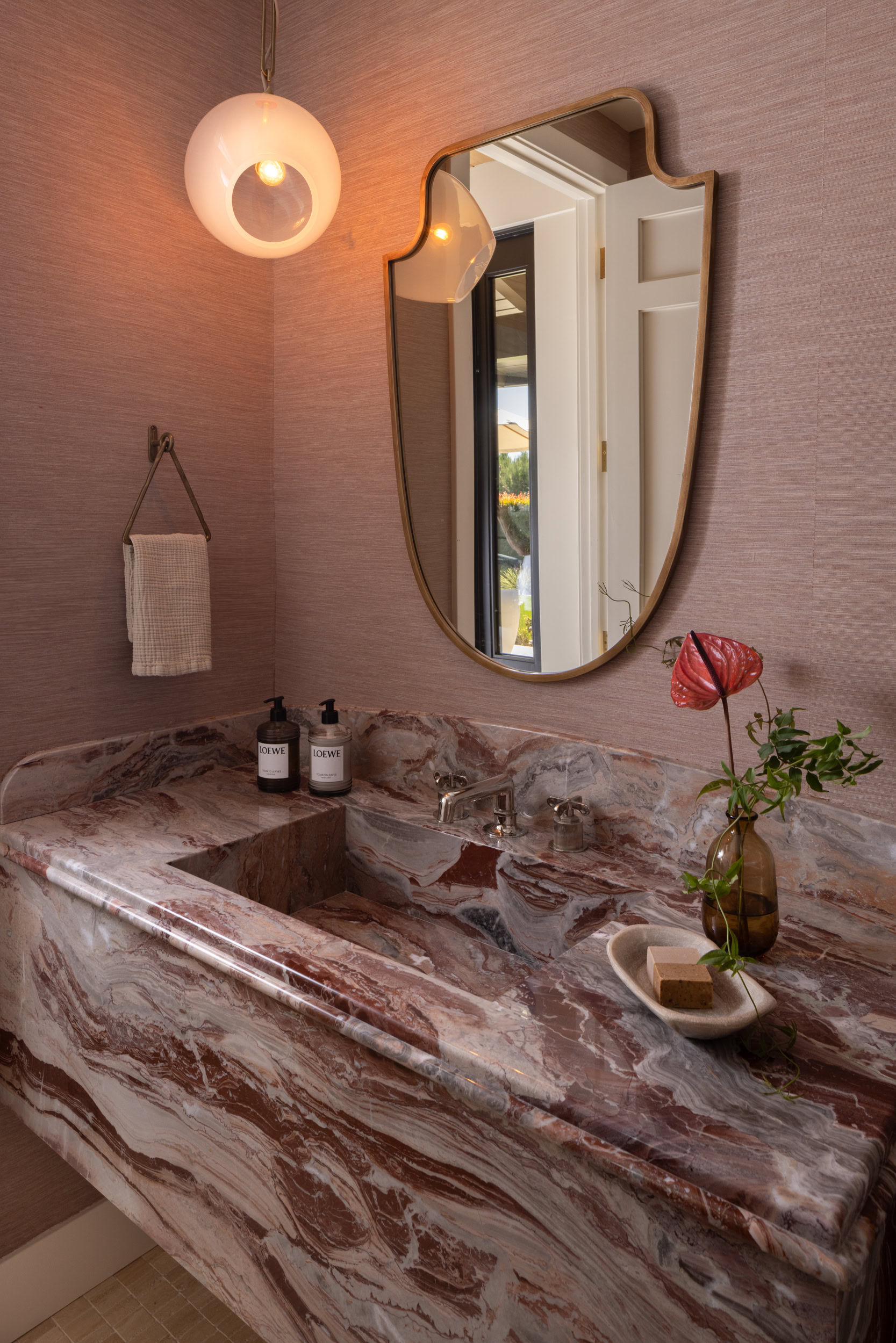 Elegant marble bathroom vanity with a stylish mirror and soft lighting.