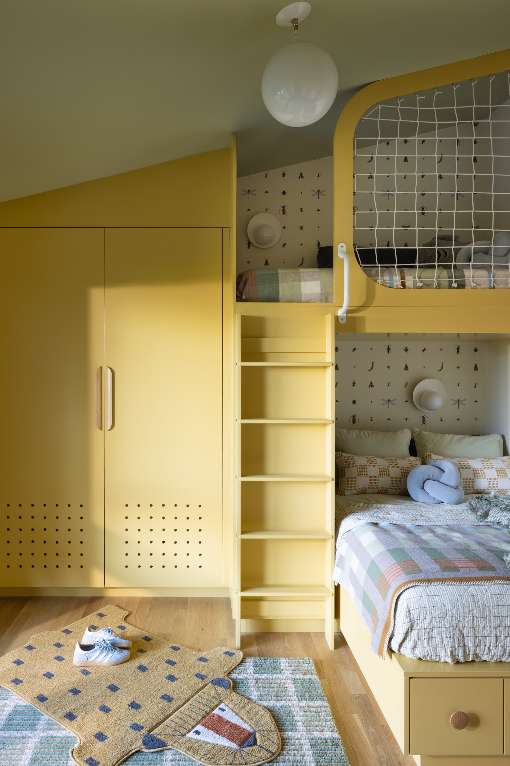 Bright yellow children's bedroom with built-in wardrobe and playful design elements.