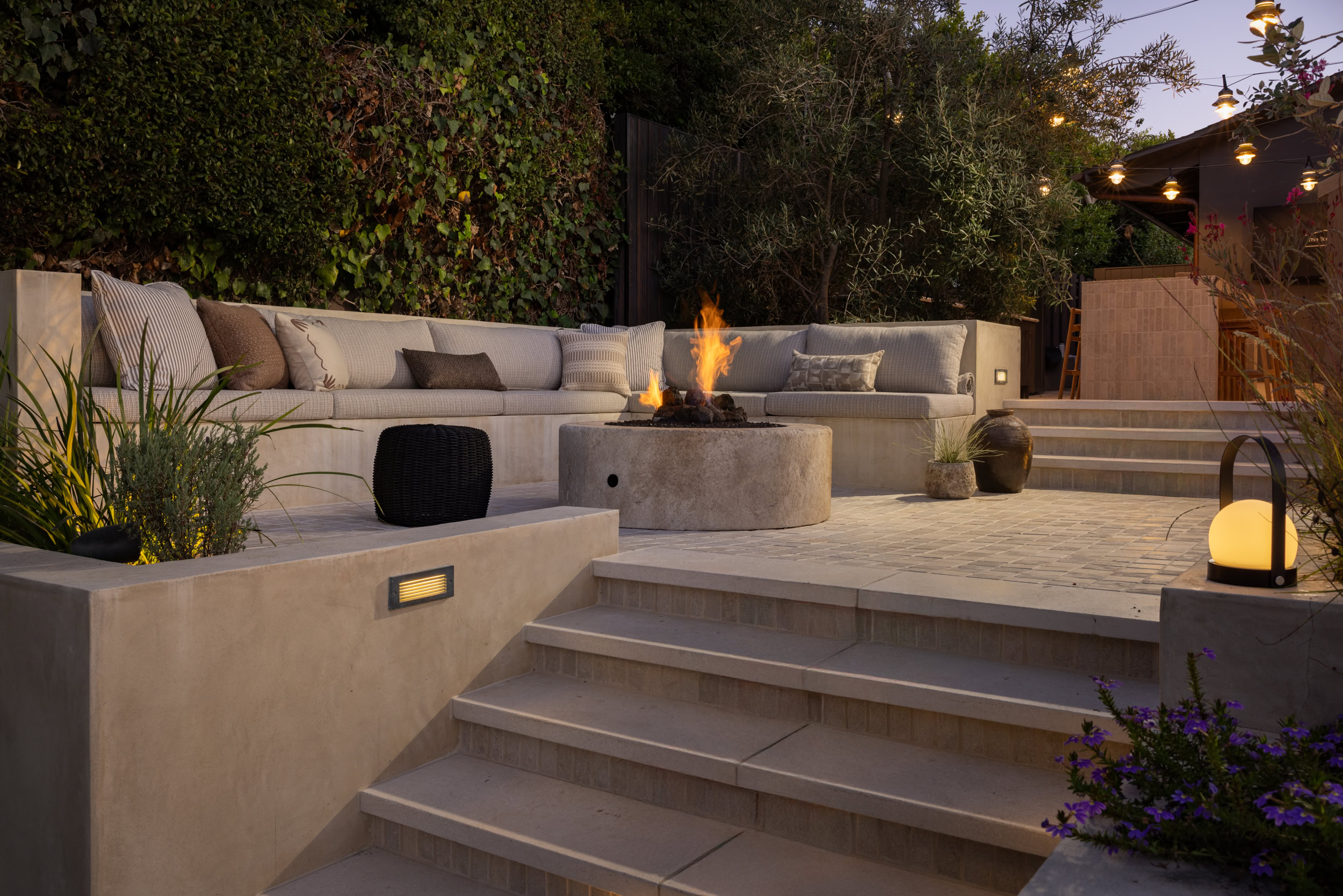 Outdoor living space with modern furniture and fire pit.
