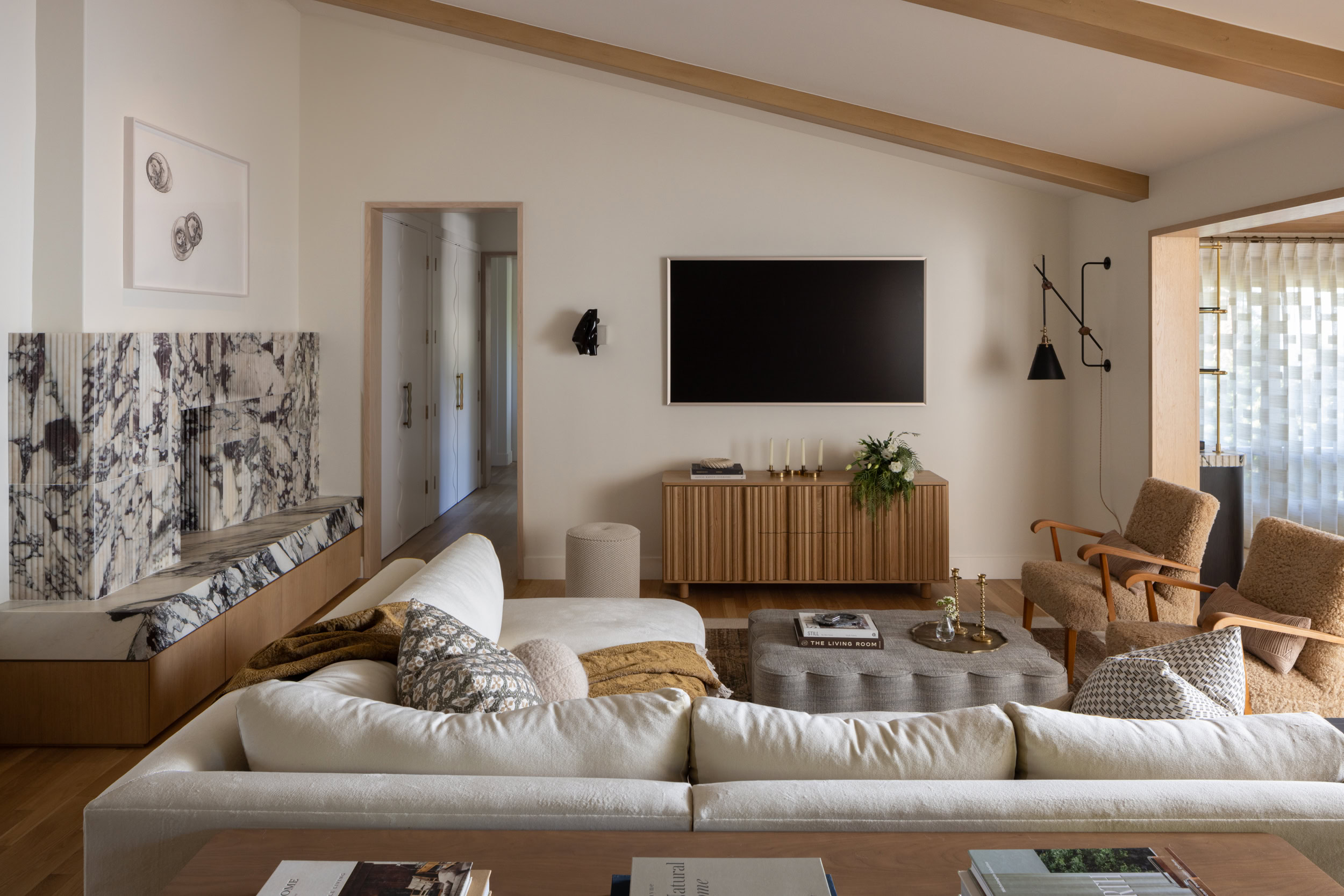Stylish living room with contemporary furniture, wall-mounted TV, and cozy seating area for relaxing.