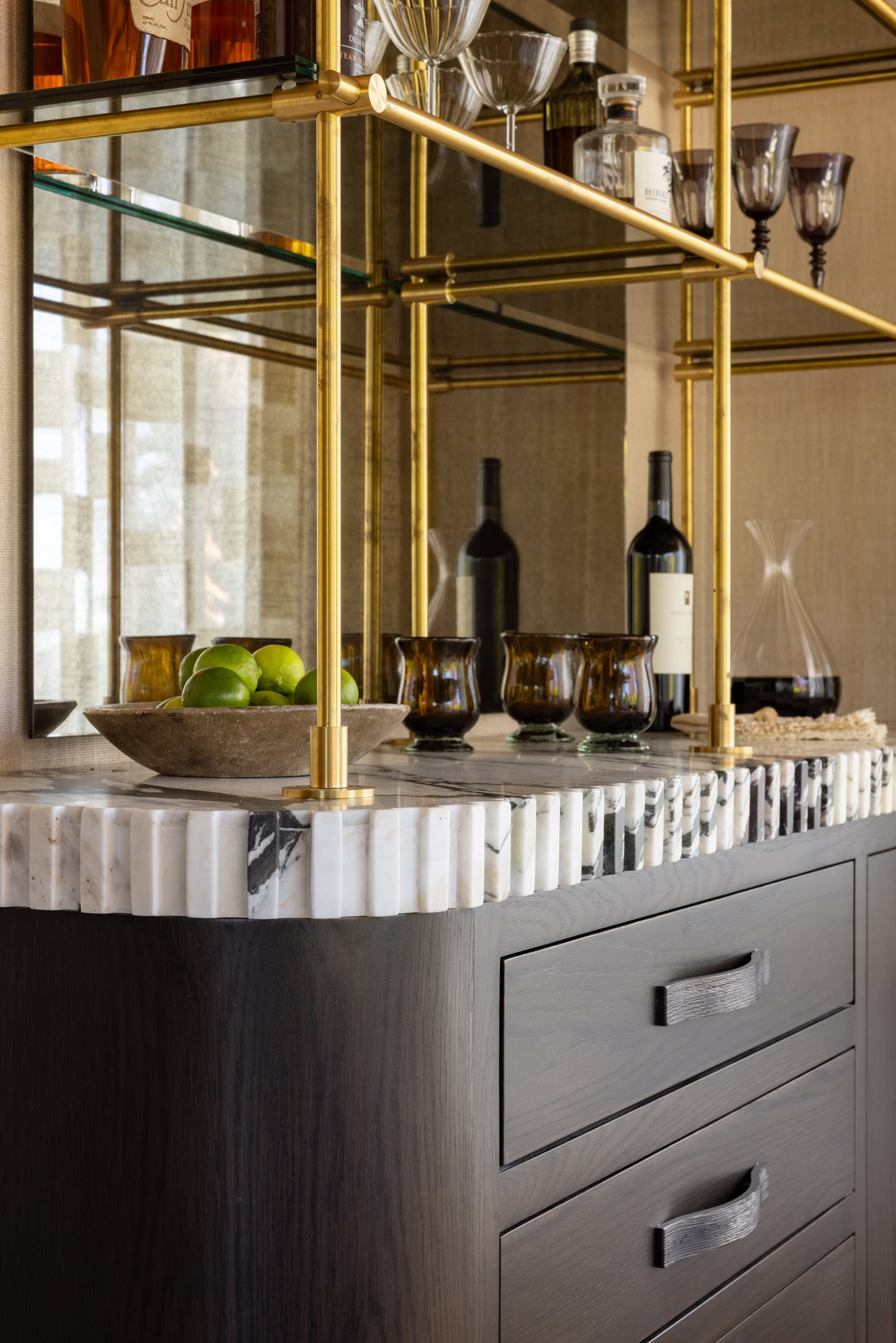 Stylish bar cart with glassware, bottles, and decorative items in a contemporary home setting.