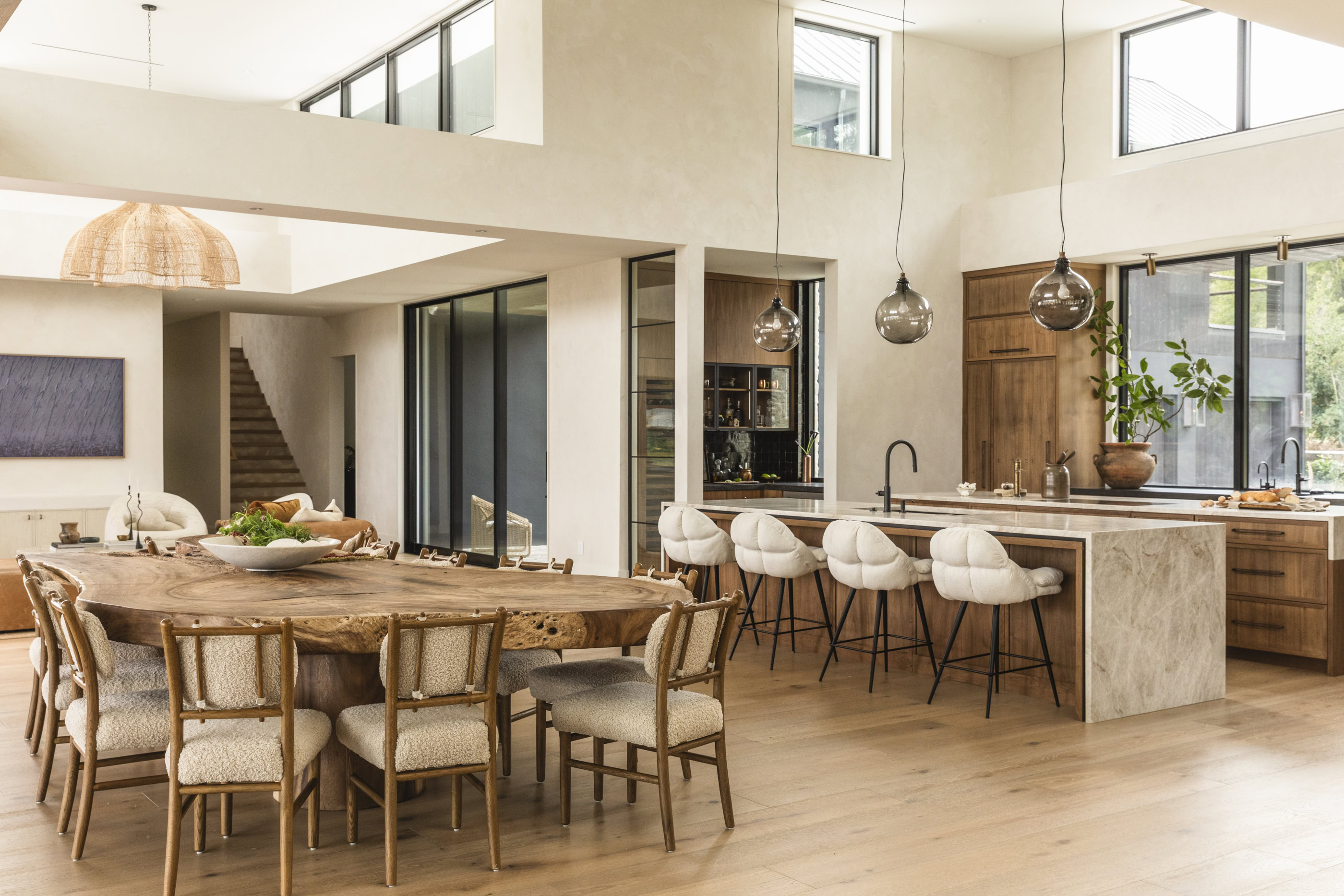 Contemporary kitchen and dining area featuring natural wood finishes and large windows.