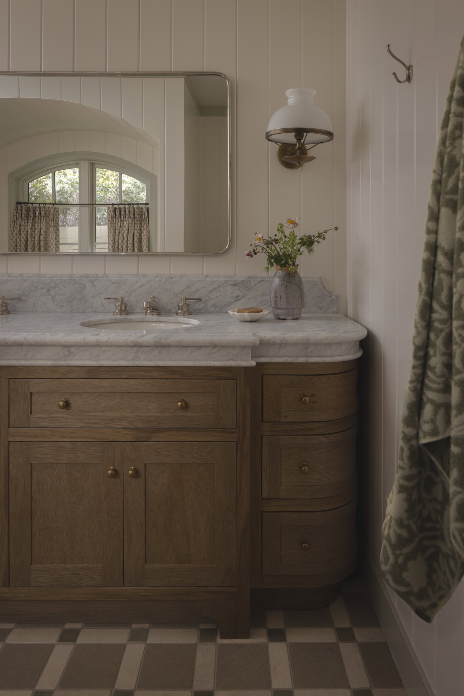 Bathroom vanity with wooden cabinet and marble countertop in cozy interior.