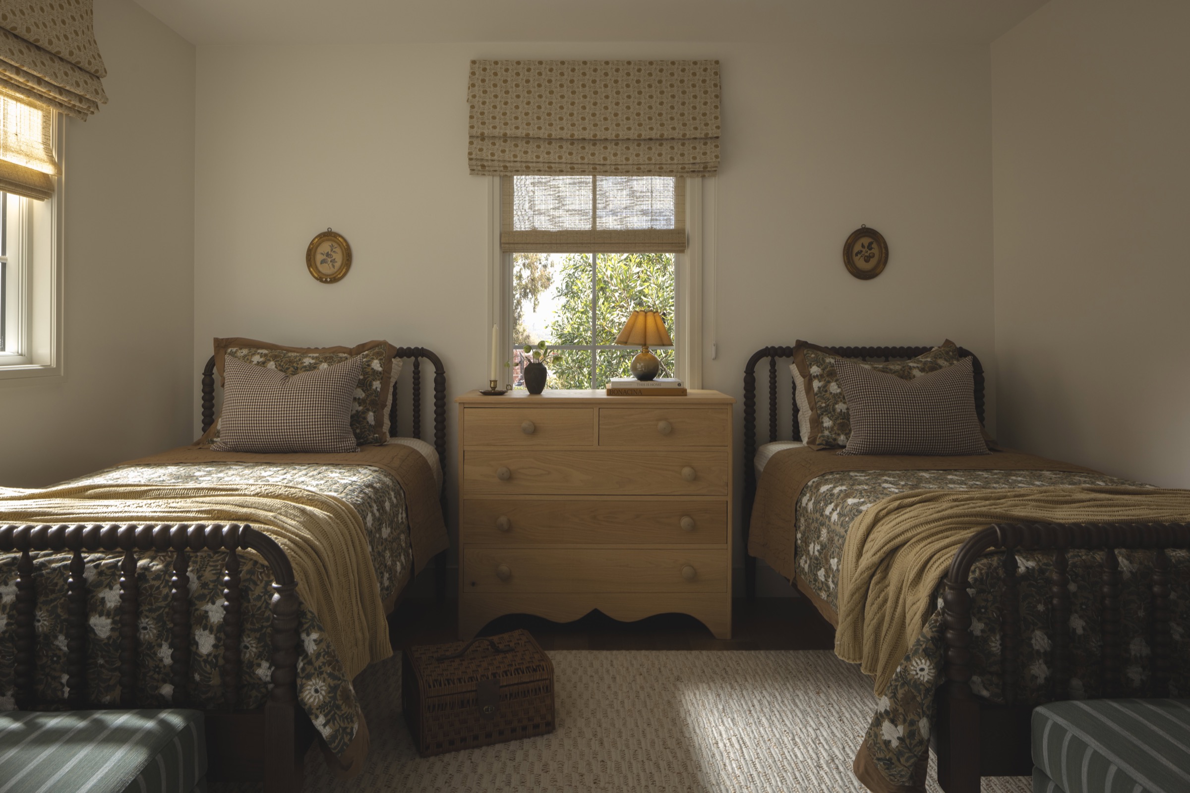 Twin bedroom with vintage furniture, soft bedding, and natural light.