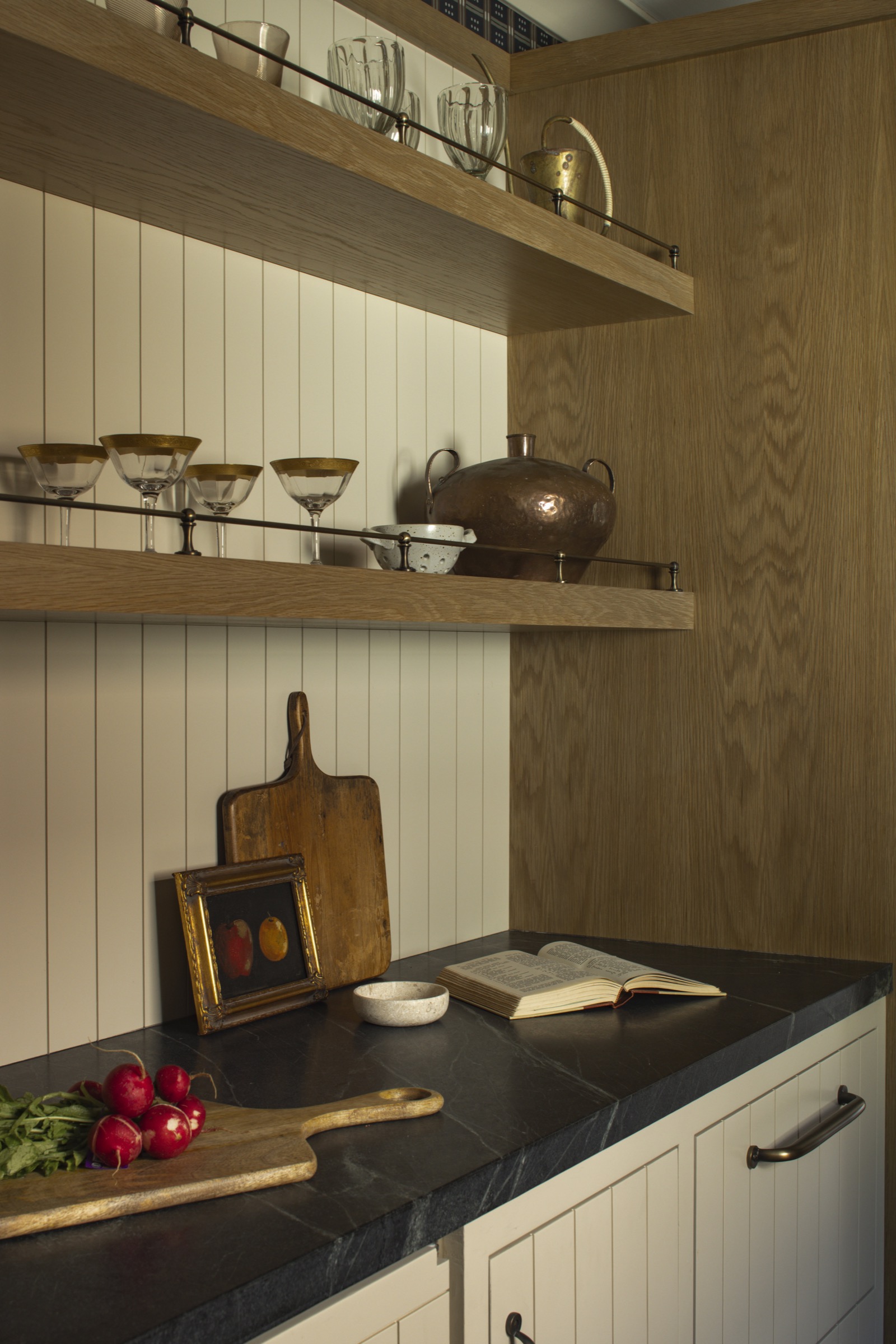 Modern kitchen with wooden open shelves, white cabinetry, and black countertop, showcasing stylish i.