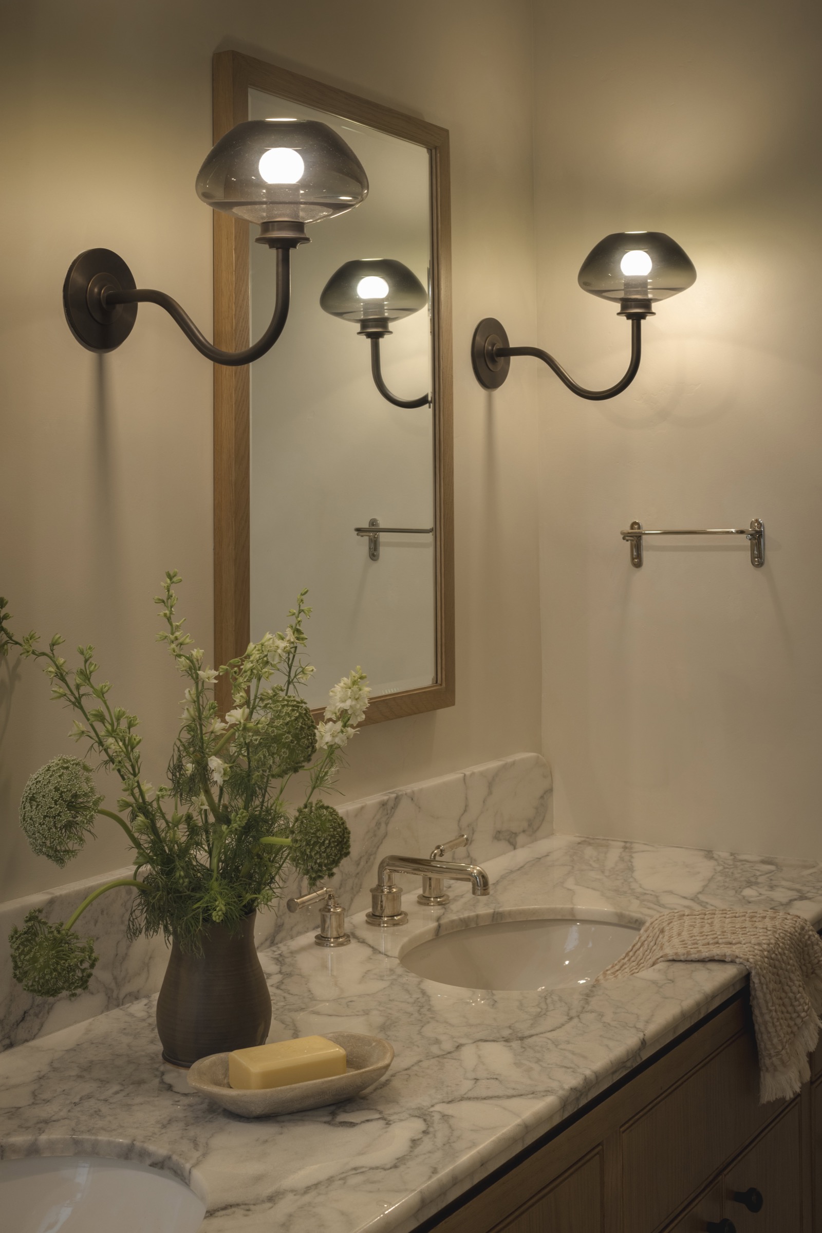 Modern bathroom vanity with stylish wall-mounted lights and marble countertop.
